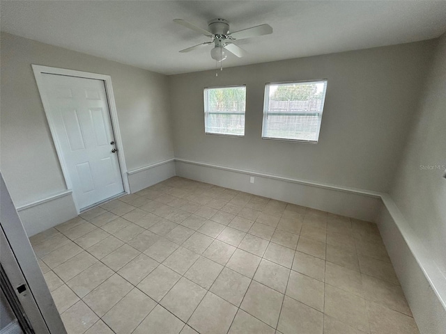 tiled spare room with ceiling fan