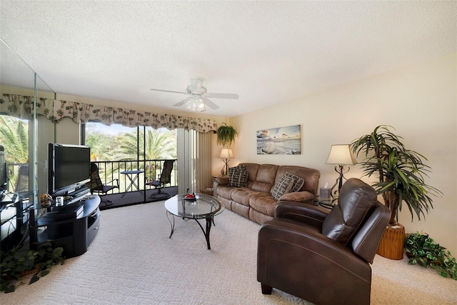 living room with ceiling fan, light carpet, and a textured ceiling