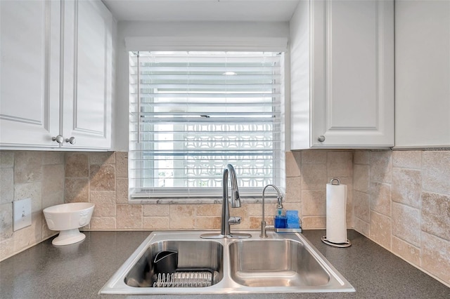 kitchen featuring sink, decorative backsplash, and white cabinets