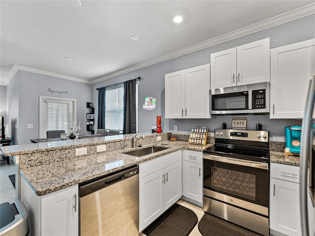 kitchen featuring appliances with stainless steel finishes, sink, white cabinets, and kitchen peninsula