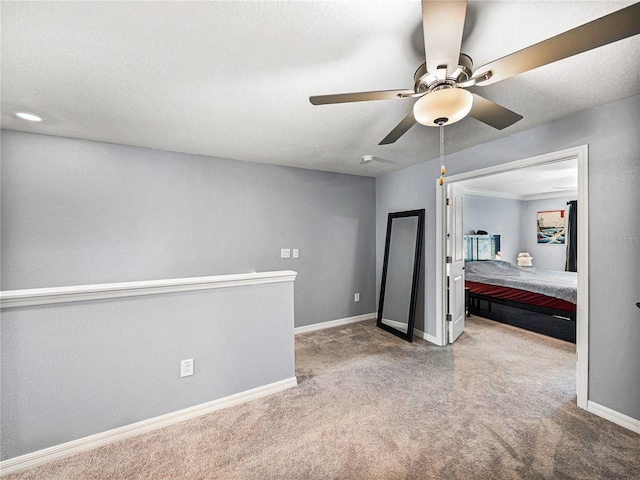 spare room featuring ceiling fan, carpet, and a textured ceiling