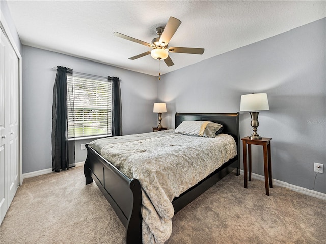 carpeted bedroom featuring a textured ceiling, a closet, and ceiling fan