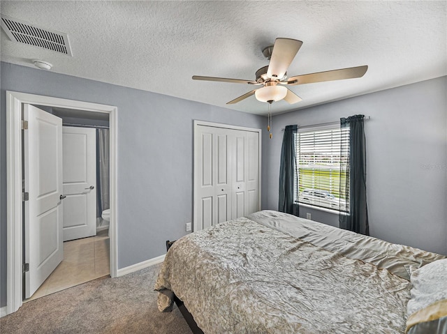 bedroom with light carpet, a textured ceiling, ceiling fan, and a closet