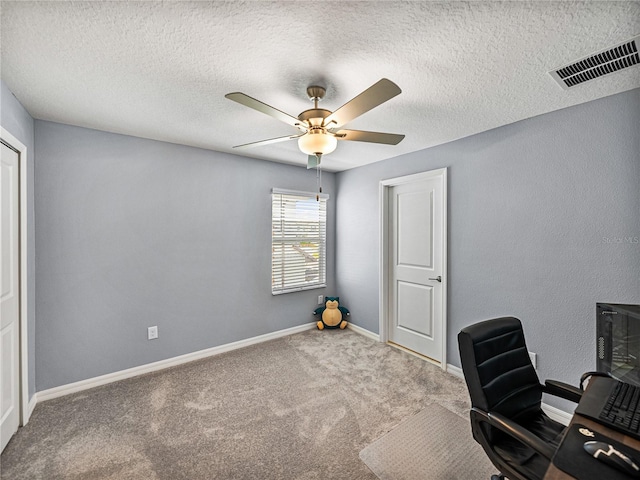 unfurnished office featuring ceiling fan, carpet floors, and a textured ceiling