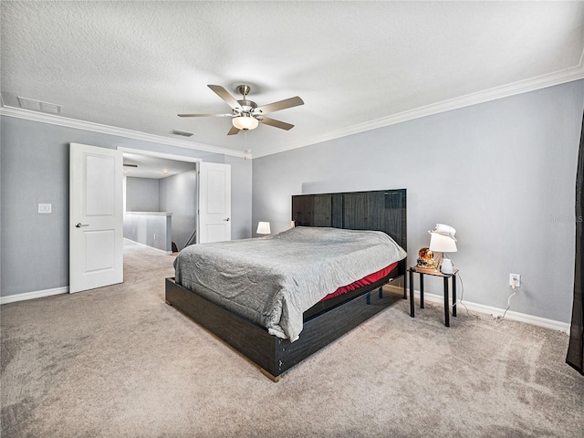 carpeted bedroom with ornamental molding, ceiling fan, and a textured ceiling