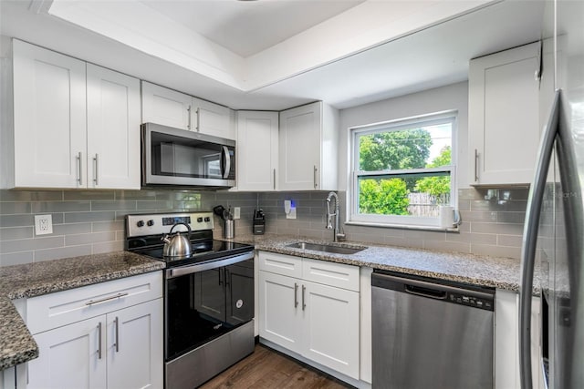 kitchen with stainless steel appliances, white cabinetry, and sink