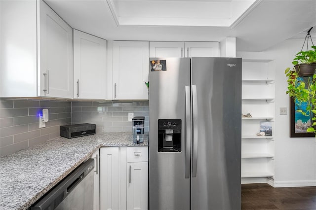 kitchen with light stone countertops, white cabinetry, appliances with stainless steel finishes, and decorative backsplash