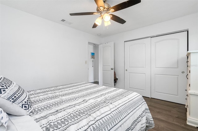 bedroom with dark wood-type flooring, ceiling fan, and a closet