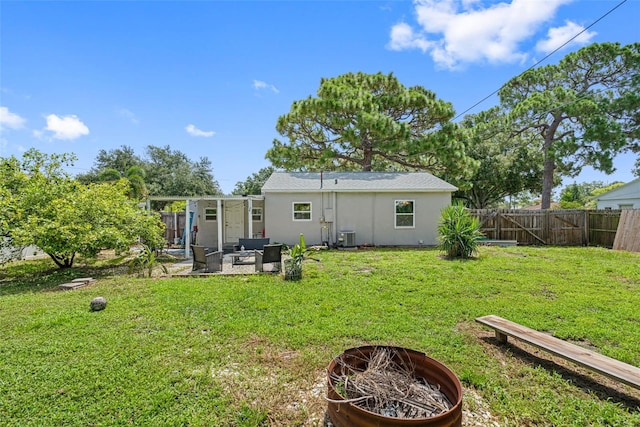 back of property featuring a lawn, an outdoor living space with a fire pit, and central air condition unit