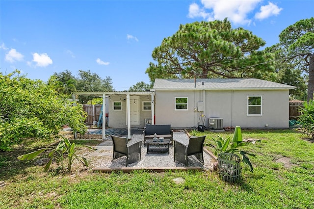 rear view of property featuring a patio, outdoor lounge area, central AC, and a lawn