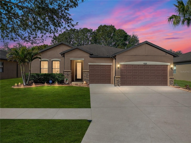 ranch-style home with a garage and a yard