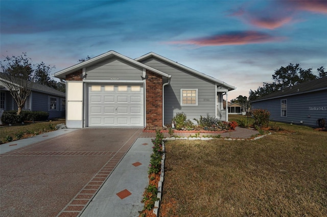 single story home featuring a yard and a garage