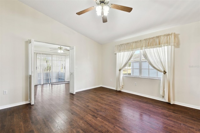 spare room featuring dark wood-type flooring, vaulted ceiling, and ceiling fan