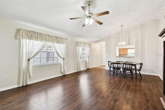 dining area featuring dark hardwood / wood-style flooring and ceiling fan with notable chandelier