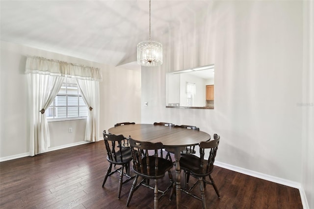 dining area featuring a notable chandelier, dark wood-type flooring, and vaulted ceiling