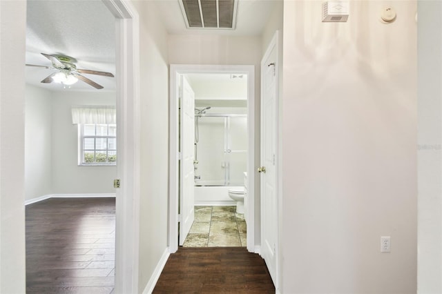 hallway with dark wood-type flooring and a textured ceiling