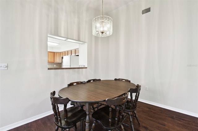 dining space featuring dark hardwood / wood-style floors and a chandelier