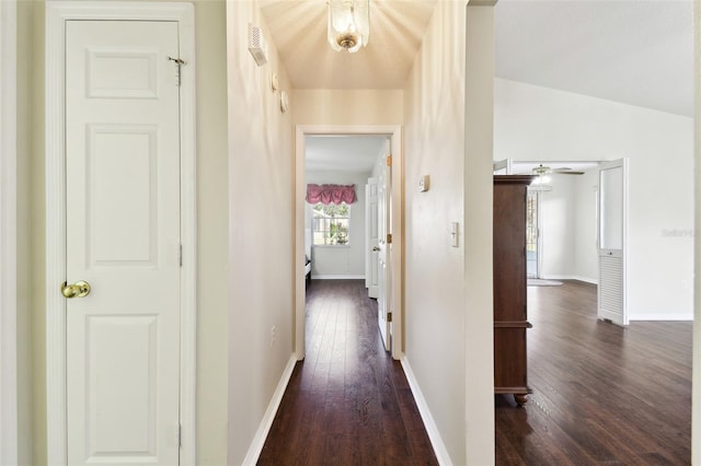 hall featuring lofted ceiling and dark hardwood / wood-style floors