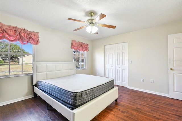 bedroom with dark wood-type flooring, ceiling fan, a closet, and a textured ceiling