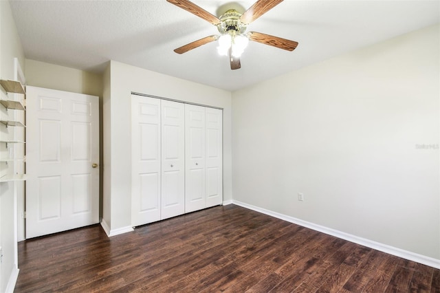 unfurnished bedroom with dark wood-type flooring, a closet, and ceiling fan