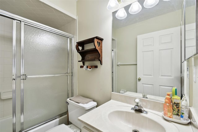 full bathroom featuring bath / shower combo with glass door, vanity, and toilet