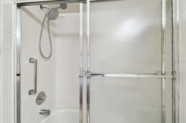 bathroom with shower / bath combination with glass door