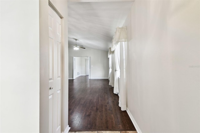 corridor featuring lofted ceiling and dark hardwood / wood-style floors