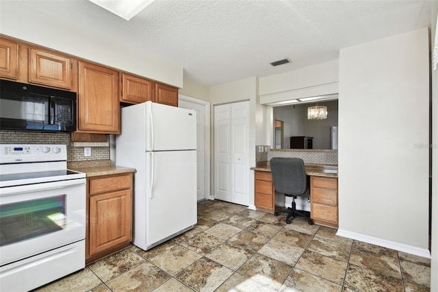 kitchen featuring tasteful backsplash, white appliances, hanging light fixtures, and a textured ceiling