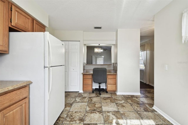 kitchen featuring white fridge and a textured ceiling