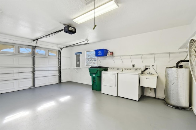 garage featuring sink, a garage door opener, water heater, washing machine and dryer, and electric panel