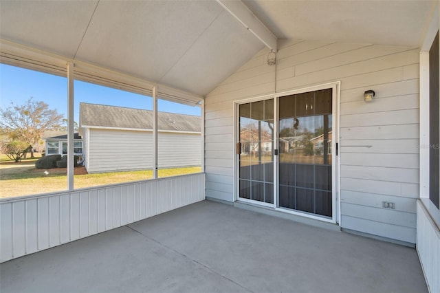 unfurnished sunroom featuring lofted ceiling with beams