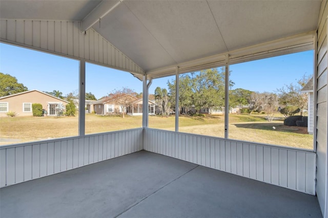 unfurnished sunroom featuring lofted ceiling with beams