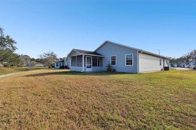 view of front of property featuring a sunroom, central AC unit, and a front lawn