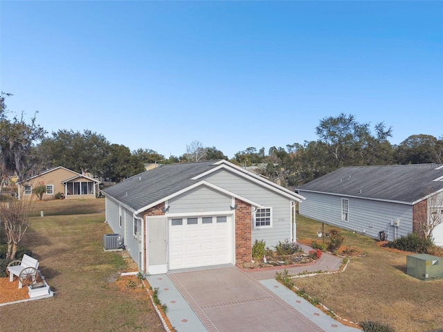 view of front of property with a garage, a front yard, and central AC unit