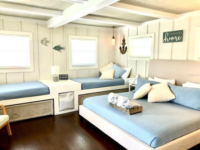 bedroom with dark hardwood / wood-style flooring and beamed ceiling