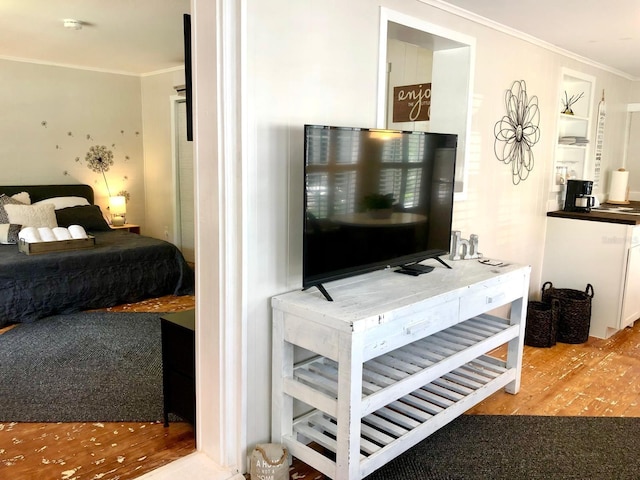 bedroom with crown molding and light hardwood / wood-style floors