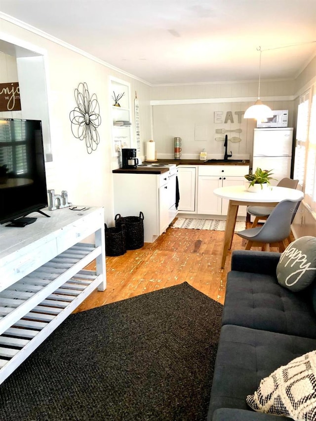 living room featuring sink and ornamental molding