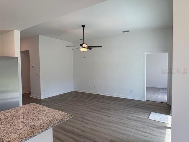 unfurnished living room with dark wood-type flooring and ceiling fan