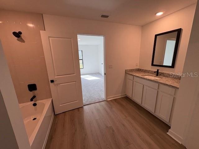 bathroom with vanity, hardwood / wood-style flooring, and shower / bath combination