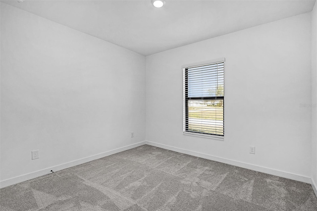empty room featuring carpet and baseboards