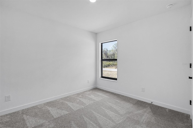 unfurnished room with baseboards and carpet floors