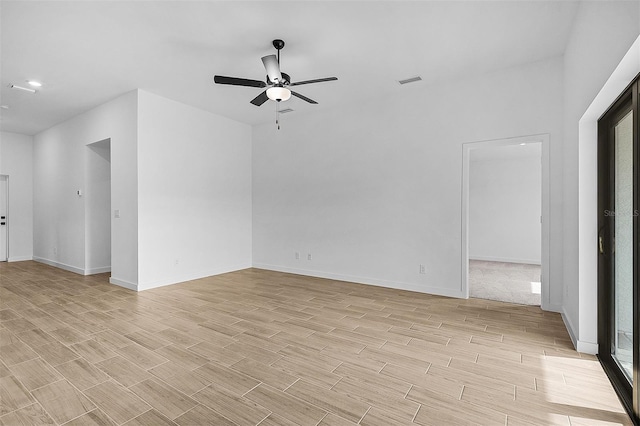 spare room with baseboards, visible vents, wood tiled floor, and ceiling fan