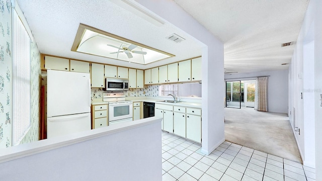 kitchen featuring sink, white appliances, ceiling fan, backsplash, and light colored carpet