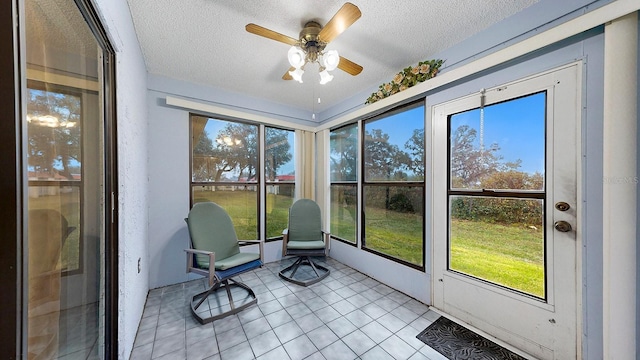 unfurnished sunroom featuring ceiling fan