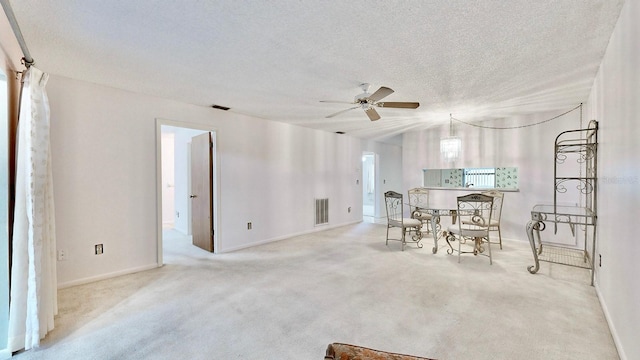 carpeted dining space with ceiling fan and a textured ceiling