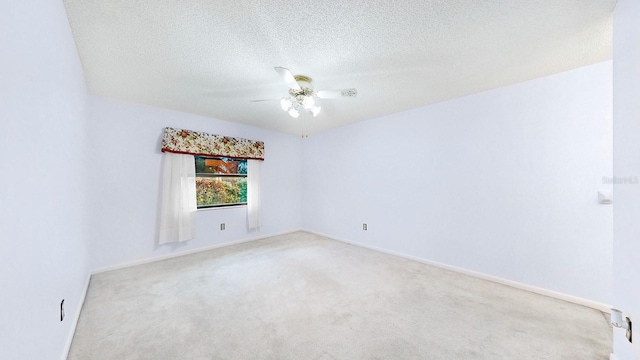 carpeted empty room with ceiling fan and a textured ceiling