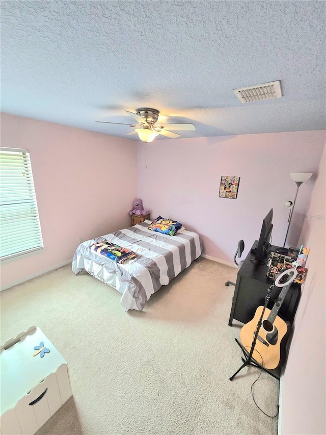 bedroom featuring carpet, ceiling fan, and a textured ceiling