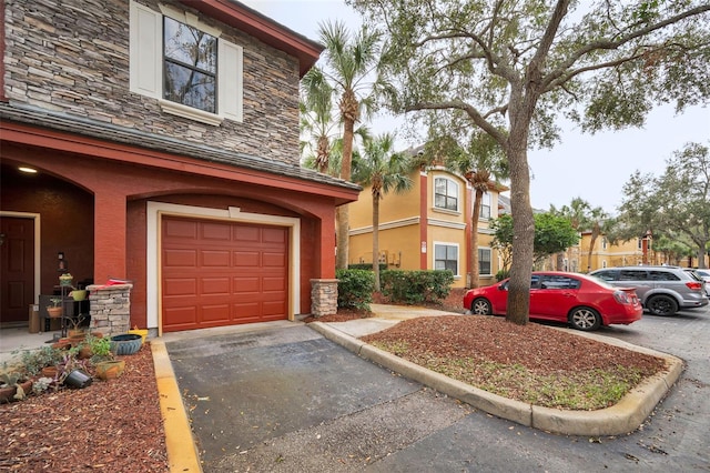 2254 Chianti Pl Unit 68, Palm Harbor, FL 34683 - view of side of home featuring stone siding, stucco siding, a garage, and driveway