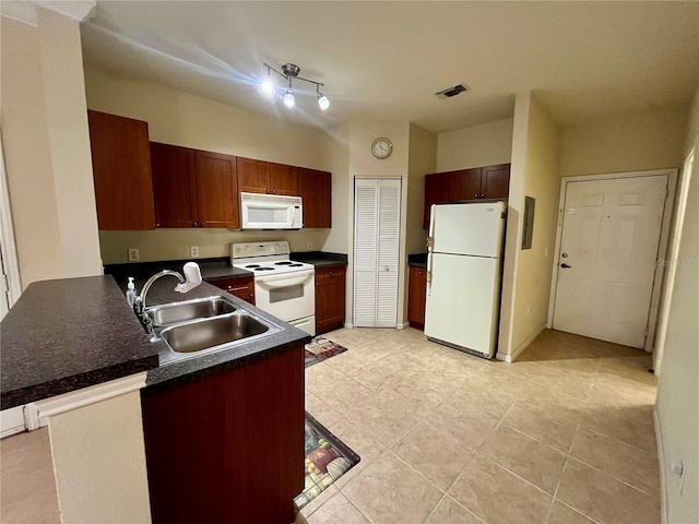 2254 Chianti Pl Unit 68, Palm Harbor, FL 34683 - kitchen featuring white appliances, a sink, dark countertops, a peninsula, and light tile patterned floors