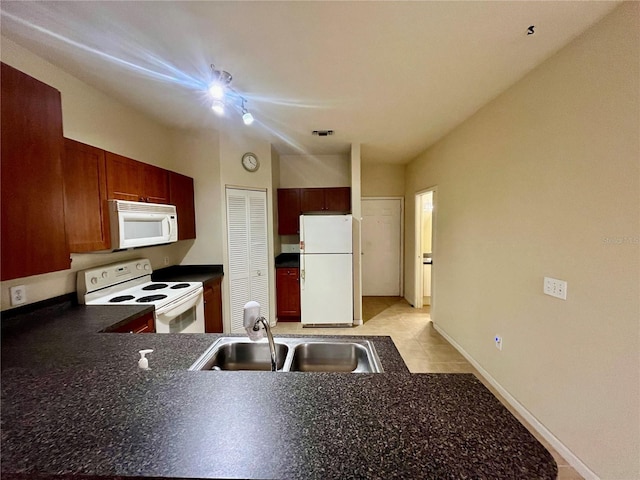 2254 Chianti Pl Unit 68, Palm Harbor, FL 34683 - kitchen with white appliances, a sink, dark countertops, baseboards, and a peninsula